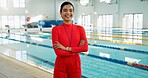 Smile, crossed arms and portrait of swimming instructor at indoor pool for lesson, workout or training. Happy, confident and woman coach with pride for competition practice at aquatic center.