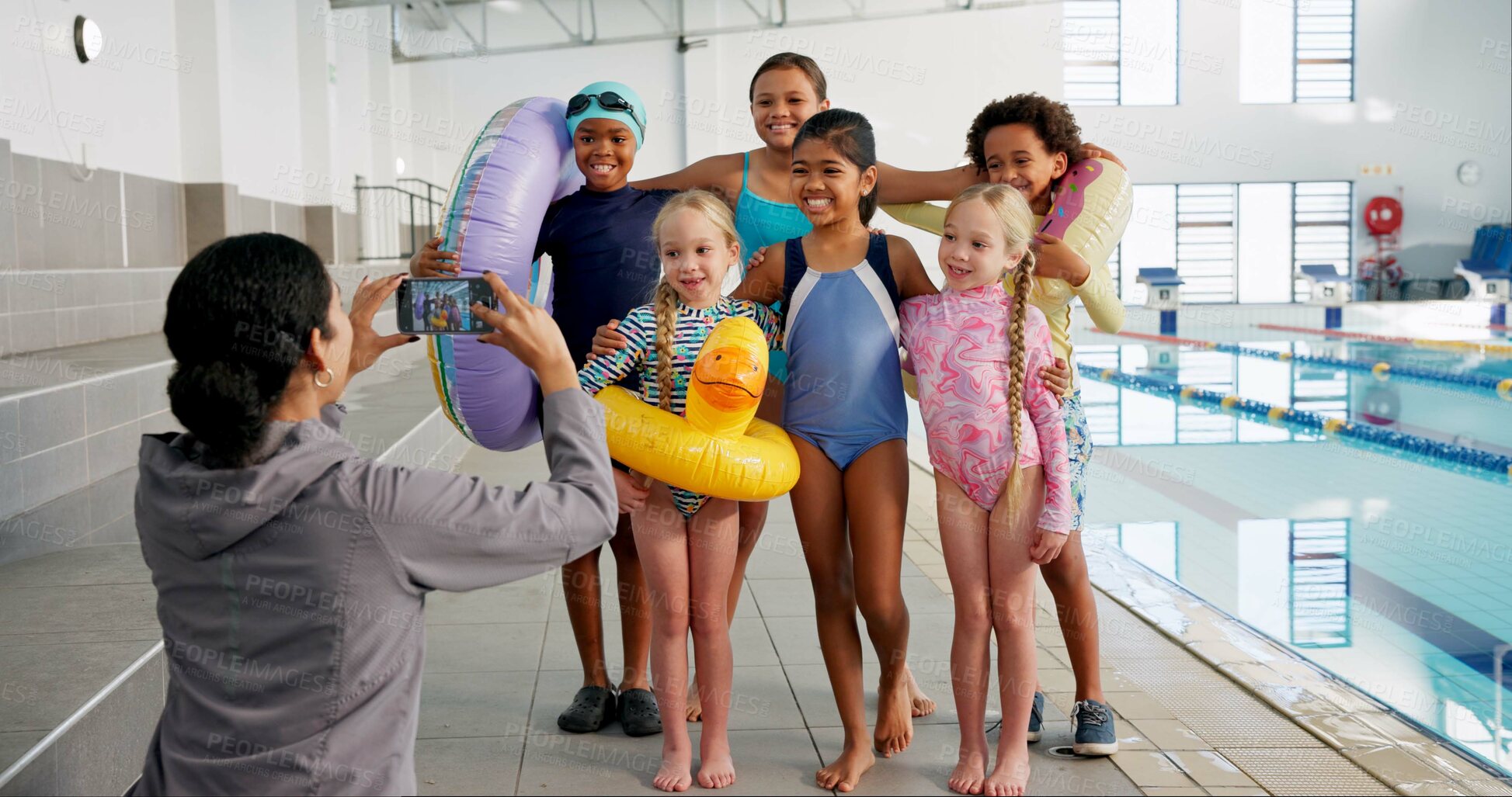 Buy stock photo Woman, smartphone and photography of children by pool for swimming lessons, website and social media post. Instructor, kids and happy indoors for profile picture, skill development and practice.