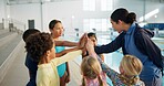 Swimming pool, lesson and teacher with kids in huddle for learning, practice and training. Teamwork, celebrate and swimmer instructor with children for exercise, fitness and water sports class