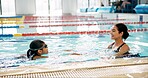 Instructor, smile and child in pool, swimming and teaching of woman, proud or helping girl in water. Bathing suit, happy and learning with teacher in school for training of kid, sports or competition