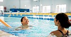 Instructor, water and girl in pool, swimming or woman with smile, proud or helping child in bathing suit. Teaching, happy or learning with teacher in school for training of kid, sports or competition