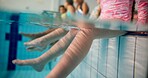 Swimming pool, kids and legs in water, playful and fun with games, recreation and happiness. Closeup, children and student with aerobics class, teaching and carefree with vacation, liquid and lessons