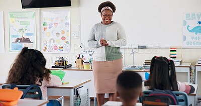 Buy stock photo Teacher, children and talking in classroom for lesson, advice or smile with assessment for development. Woman, child and quiz for education, info or knowledge for help, happy or scholarship at school