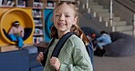 Portrait, girl and smile with backpack, library and happy for education in academy and joy for learning. Scholarship, proud and student studying in USA, confident and back to school, youth and bag