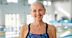 Elderly woman, portrait and smile for swimming, wellness and mental health by indoor pool facility. Senior person, face and happy in retirement with exercise for fitness, arthritis or aquatic therapy