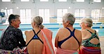 Senior people, back and class for swimming, wellness and mental health by indoor pool facility. Elderly group, rear view and fun in retirement with diversity for fitness, exercise and rehabilitation