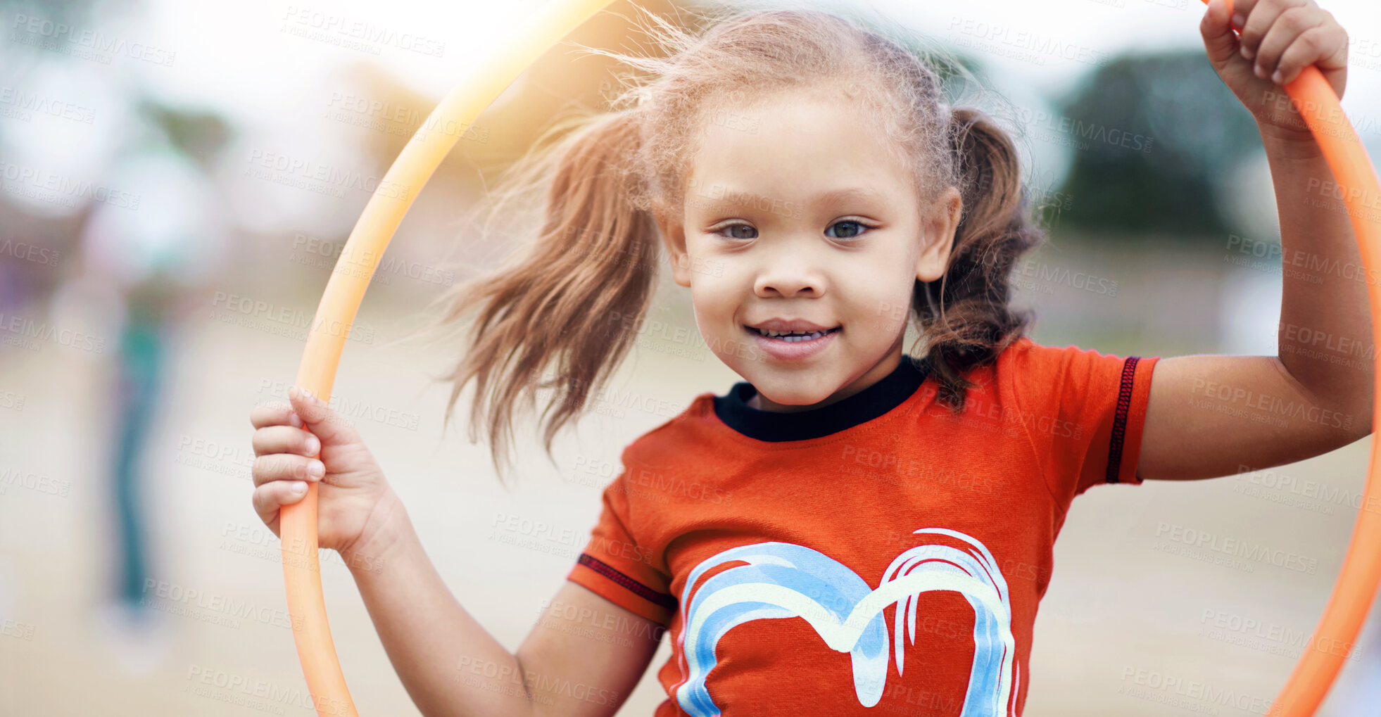 Buy stock photo Portrait of girl holding a hoola hoop outside in a playground. Cute smiling preschooler playing on a summer day during school vacation. Active african child having fun against a blurred background