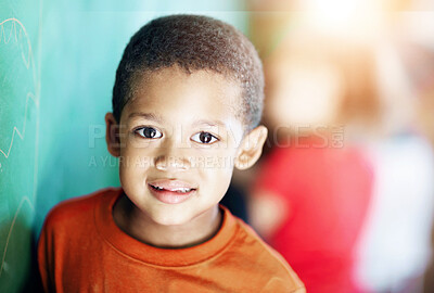 Buy stock photo Sweet little boy standing at the chalkboard in a classroom