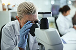 Scientist, mature woman and microscope in laboratory for sample analysis, medical research or discovery. Biotechnology, professional or equipment for clinical experiment, science study or DNA testing