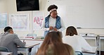 Education, woman and teacher with students in classroom for biology exam, science test and writing assessment. High school, educator and monitor learners at academy for research project and learning