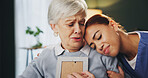 Senior woman, sad and grief in retirement home with caregiver, picture frame and reflection as pensioner. Female person, upset and crying for love, memory and support in elderly care, peace and hug