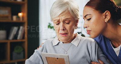 Buy stock photo Senior woman, sad and remember in nursing home with caregiver, photograph and reflection as pensioner. Female person, upset and crying for love, memory and support in elderly care, peace and security