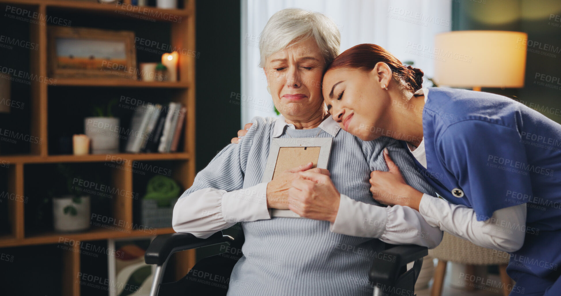 Buy stock photo Senior woman, nurse and grief with picture frame, hug and nursing home for elderly care, support and depression. Female people, sadness and crying for loss, memory and caregiver as widow or pensioner