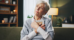 Photograph, sad and thinking with senior woman on sofa in living room of retirement home for grief. Loss, memory and pain with unhappy elderly person in apartment for mourning, reflection or regret