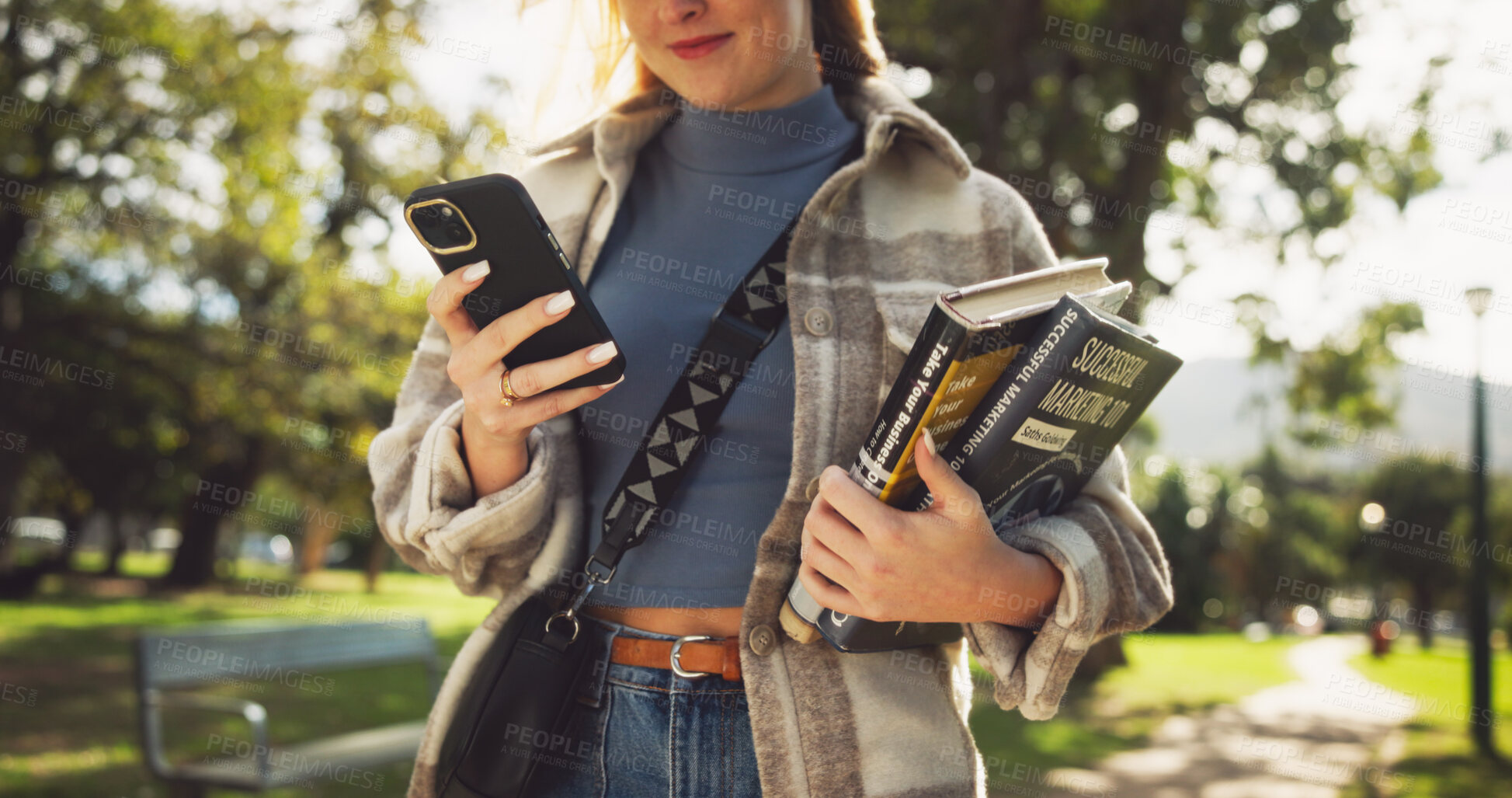 Buy stock photo Student, hands and books in park with phone on walk with education, learning or thinking for development at campus. Person, smile and app on path, social media and scholarship at college in Germany