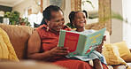 Grandmother, child and laugh with book for education or smile, learning literature and fantasy storytelling. Black family,  reading and creative knowledge of support, language growth or care at house