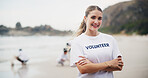 Girl, charity and volunteer at beach for cleaning, recycling and environment sustainability with smile. Woman, ngo and crossed arms by ocean sand for community service, portrait and earth day project