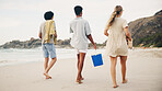 Friends, back and walking on beach for picnic with basket, beer and fun on travel vacation in summer. Men, girl and together by ocean with alcohol for drinking, conversation and bonding on holiday.