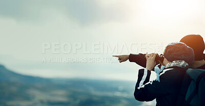 Buy stock photo A young couple looking at the view through their binoculars while on a hike