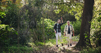 Buy stock photo Father, son and hiking for fitness outdoor with backpacking support, trekking adventure and point for forest direction. Senior man, family and travel for exercise, bonding and explore nature in woods
