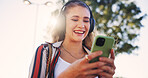 Girl, phone and headphones outdoor for music, communication and social media with smile and streaming. Female person, smartphone and walking in city for networking, travel and mobile app with radio