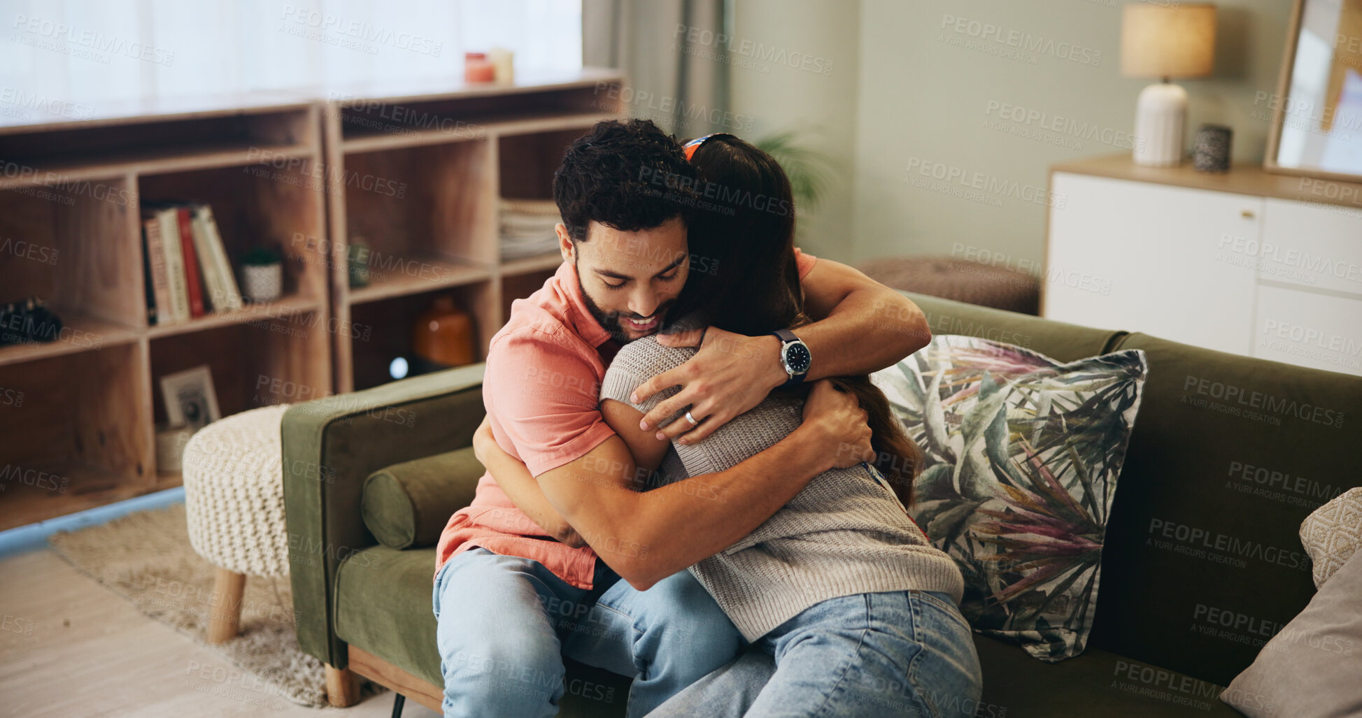 Buy stock photo Couple, hug and love on sofa in home with support, care and bonding with connection in relationship. Man, woman and embrace on couch in lounge with smile, relax and living room at house in Colombia