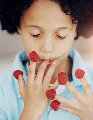 Buy stock photo A cute young boy eating raspberries off his fingers with his eyes closed