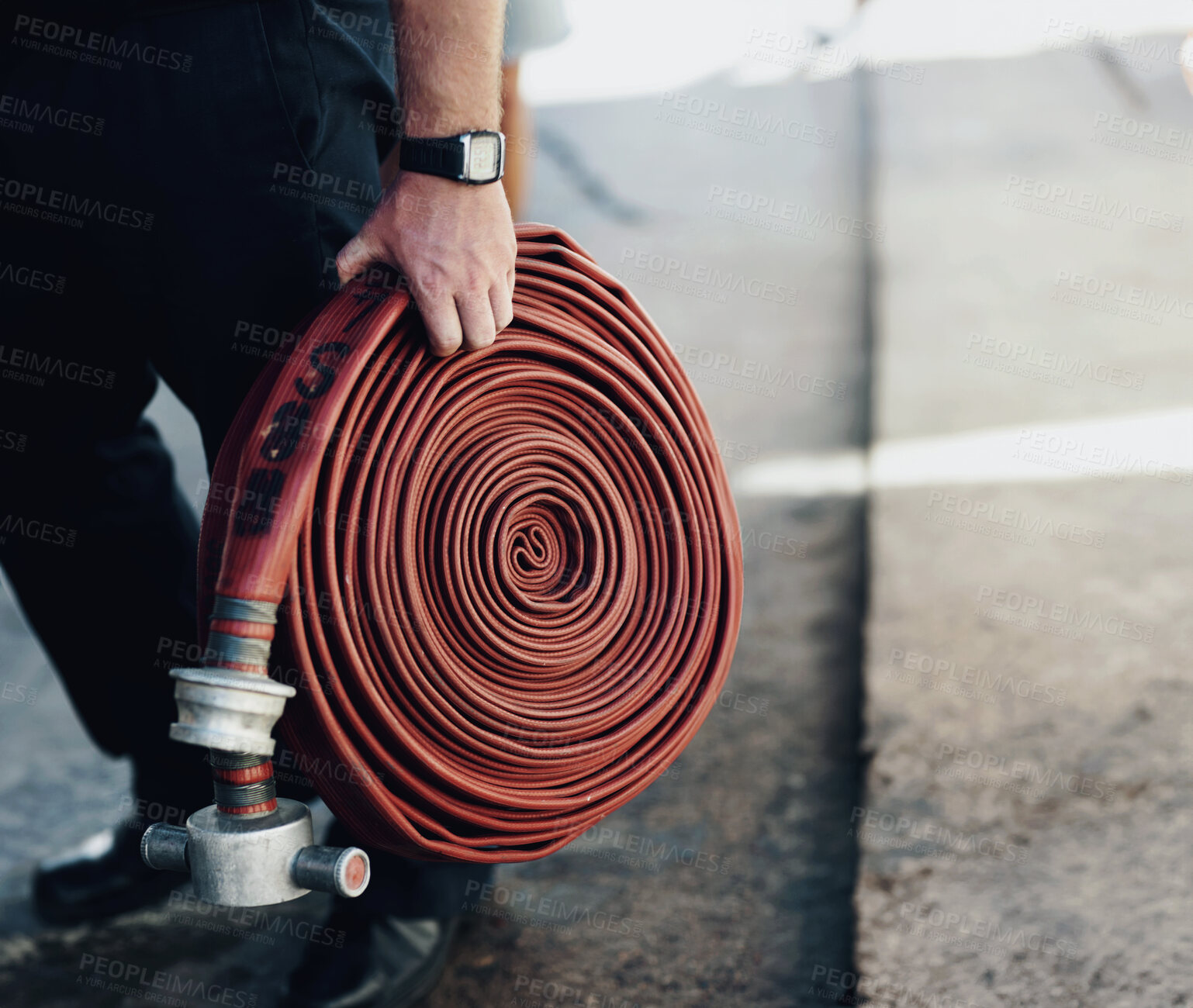 Buy stock photo Person, outdoor and hand with fire hose for service, emergency and first responder on street. Firefighter, volunteer and hosepipe in coil for safety, fireman and ready or fearless for career danger