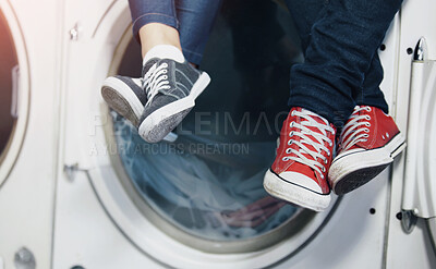Buy stock photo Cropped image of a couple's feet as they sit on a washing machine at the laundromat