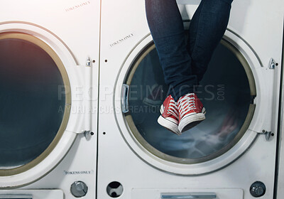 Buy stock photo Cropped image a man's legs as he sits on a washing machine at the laundromat