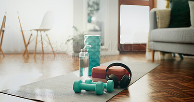 Buy stock photo House, floor and mat with gym equipment in room for home cardio workout, health or wellness. Water, headphones and interior with dumbbell on ground for exercise music, streaming or training hydration