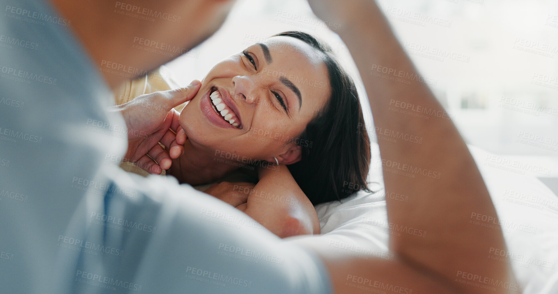 Buy stock photo Couple, relax and touch face on bed for love, romance and funny storytelling in home. Man, woman or happy in bedroom with trust, commitment and enjoy weekend sleep in with fun, joke and good memories