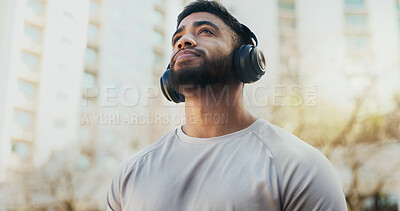 Buy stock photo Fitness, headphones and man in city for running, workout or training for race endurance or stamina. Thinking, sports and male athlete with audio tech for podcast, music or radio with cardio exercise.