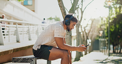 Cellphone, headphones and man with fitness, outdoor and fatigue with sound, listening to music and typing. Person, runner or athlete with headset, smartphone or song for motivation, exercise or calm