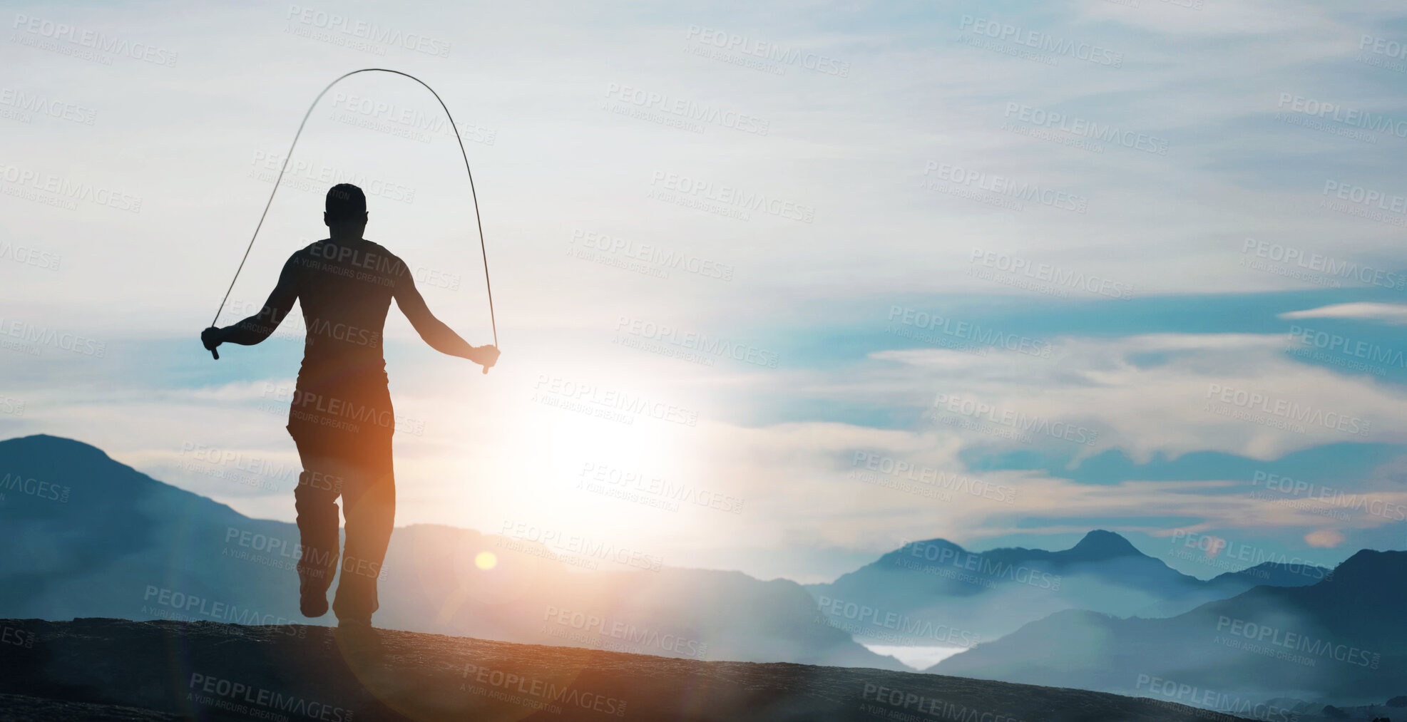 Buy stock photo Rearview of a man skipping on a mountain top