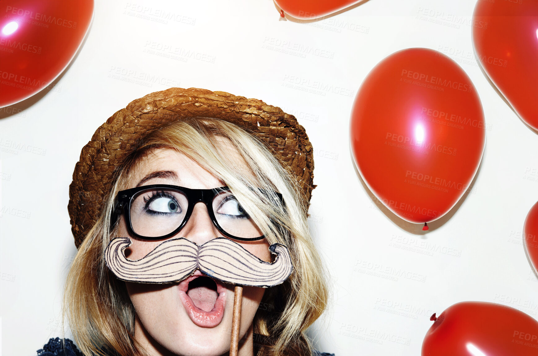 Buy stock photo Closeup of a young woman holding a moustache prop up to her face and looking surprised