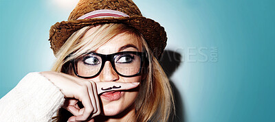 Buy stock photo Girl, isolated and hipster pose with mustache on finger, nerd glasses or funny face in studio white background. Young woman, modern fashion and moustache joke or goofy, weird and photobooth 