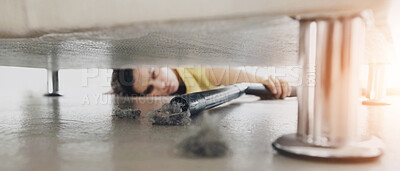 Buy stock photo Young woman reaching under a sofa to get at some dust