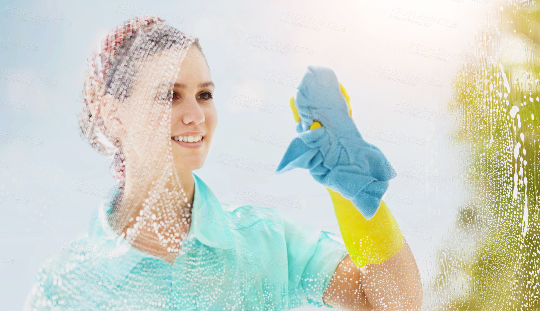 Buy stock photo A happy woman cleaning a window on a bright sunny day, enjoying fresh air with copyspace. Smiling domestic cleaner doing chores, spring cleaning, wiping glass and clearing dirt with a soapy rag