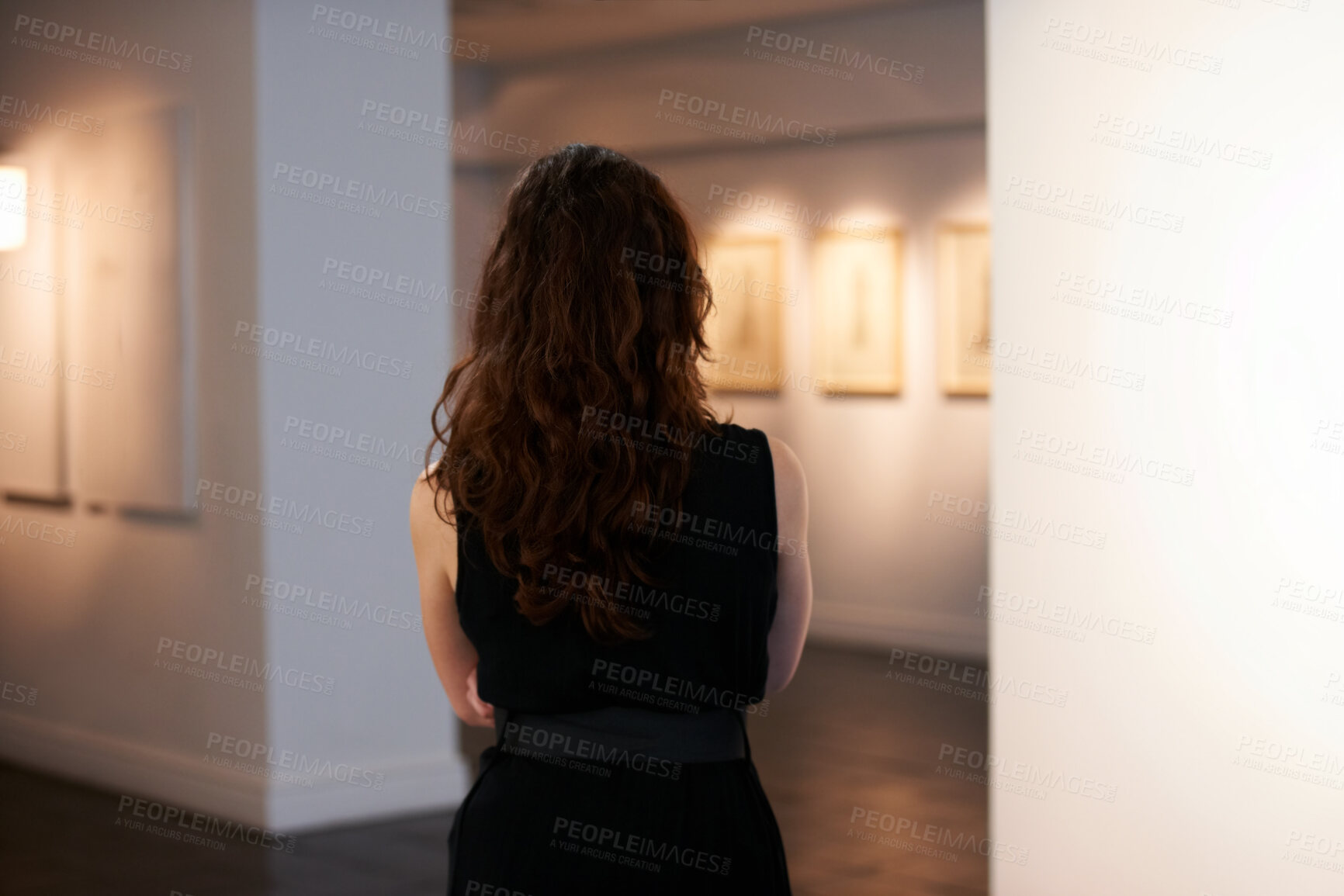 Buy stock photo Shot of a young woman looking at paintings in a gallery