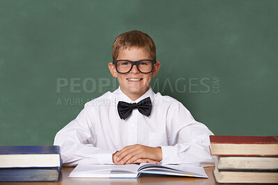 Buy stock photo Boy child, books and school in portrait with smile, information and knowledge with pride in classroom. Student kid, happy and excited for education, learning and development by chalkboard at desk