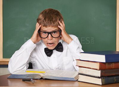 Buy stock photo Boy child, stress and portrait with books, classroom and anxiety for exam, assessment and studying for knowledge. Student kid, notebook and learning for education, development and glasses at table