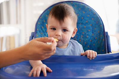 Buy stock photo Baby, hand and spoon for feeding food in chair for morning nutrition in apartment for eating meal, development or lunch. Kid, childcare and fingers for toddler dinner or wellness, hungry or vitamins