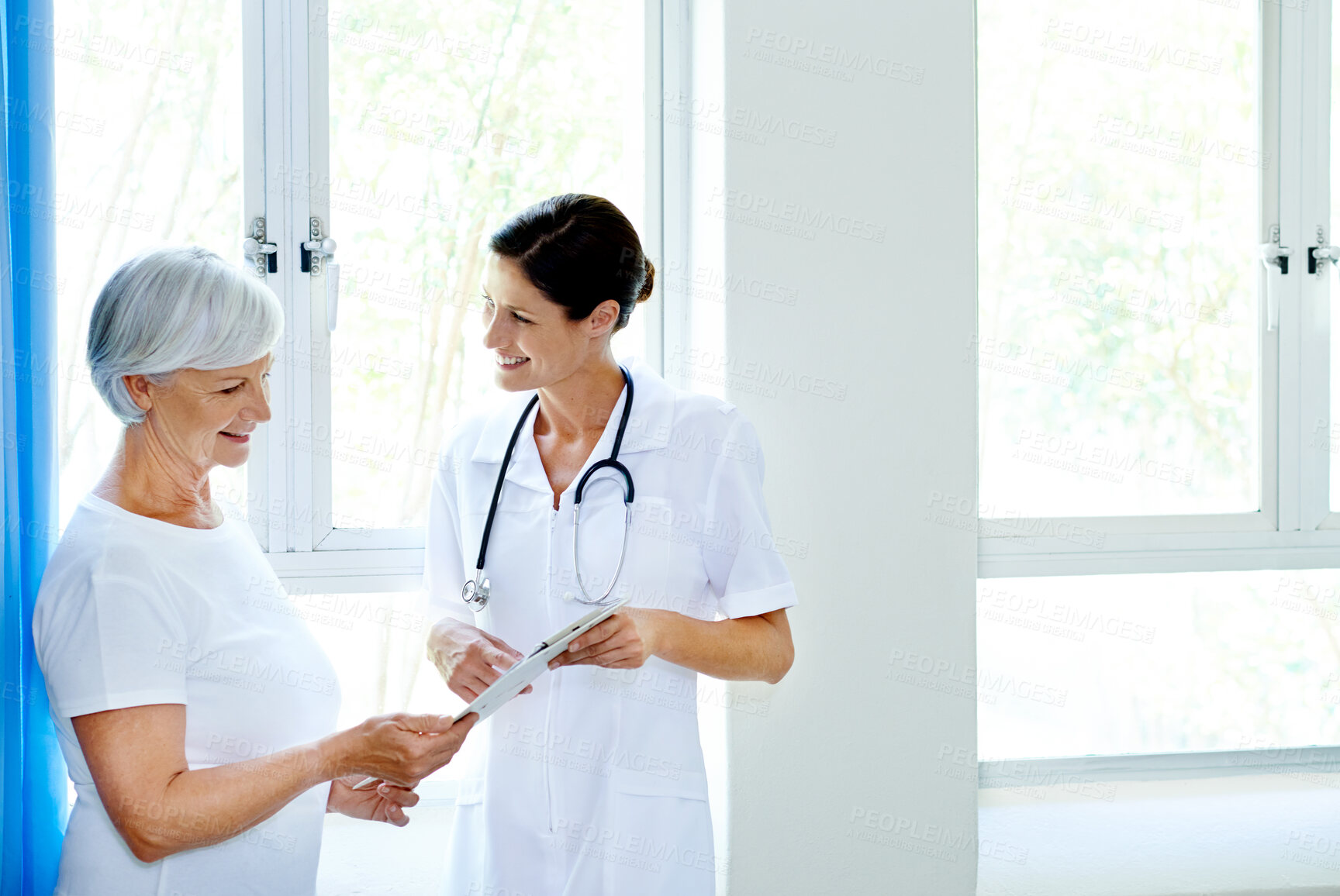 Buy stock photo Communication, clipboard and nurse with old woman, smile and happy for results of diagnosis for patient. Hospital, medical professional and documents for elderly person, treatment and healthcare