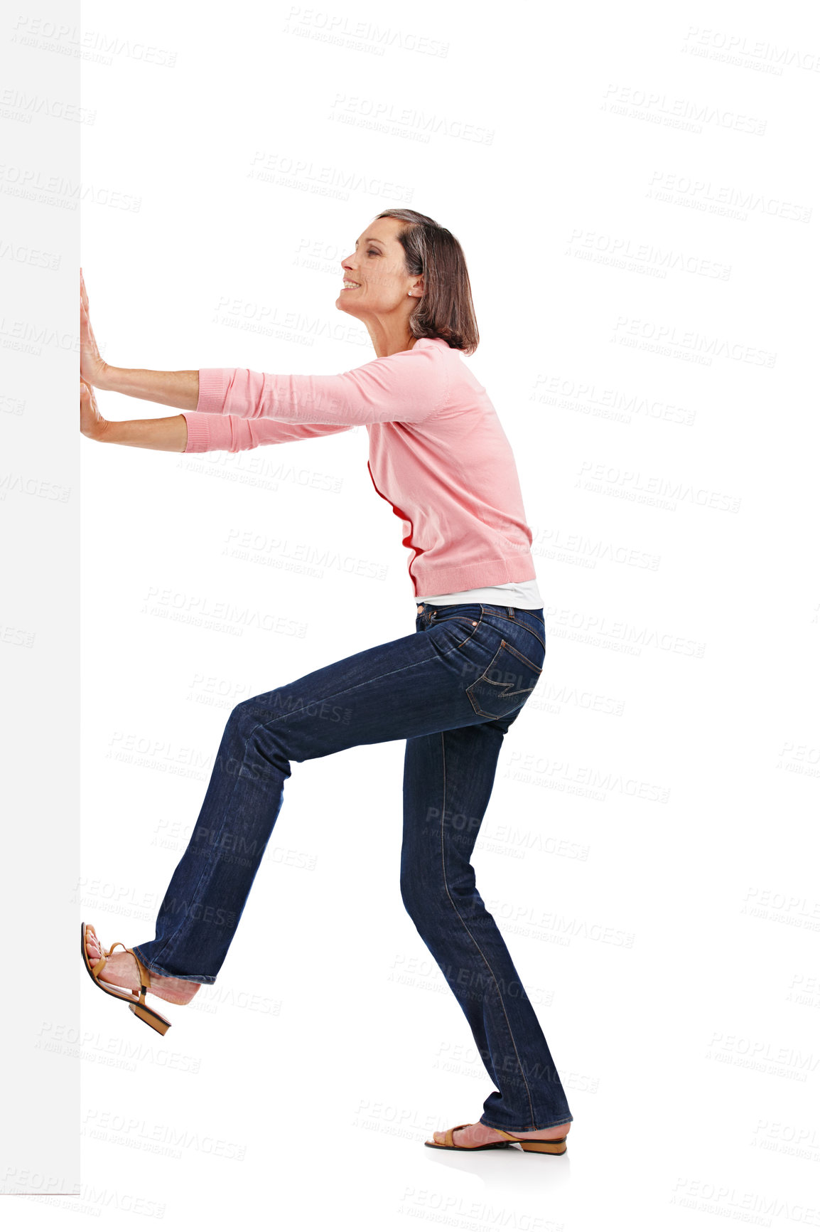 Buy stock photo Mature woman, wall and pushing with body for rearrangments or change in studio on a white background. Female person, fashion and model moving heavy object, barricade or board in casual clothing