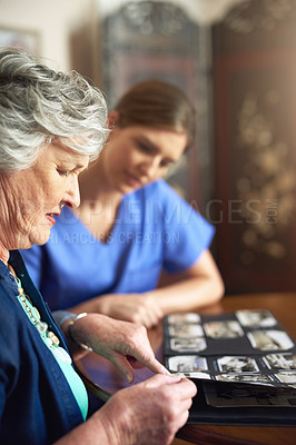 Buy stock photo Nurse, senior woman and photo album in retirement, sad and pictures for nostalgia in nursing home. Female person, caregiver and support dementia patient with history or past life, stress and memory