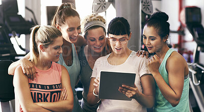 Buy stock photo Cropped shot of a group of young women looking at a digital tablet in the gym