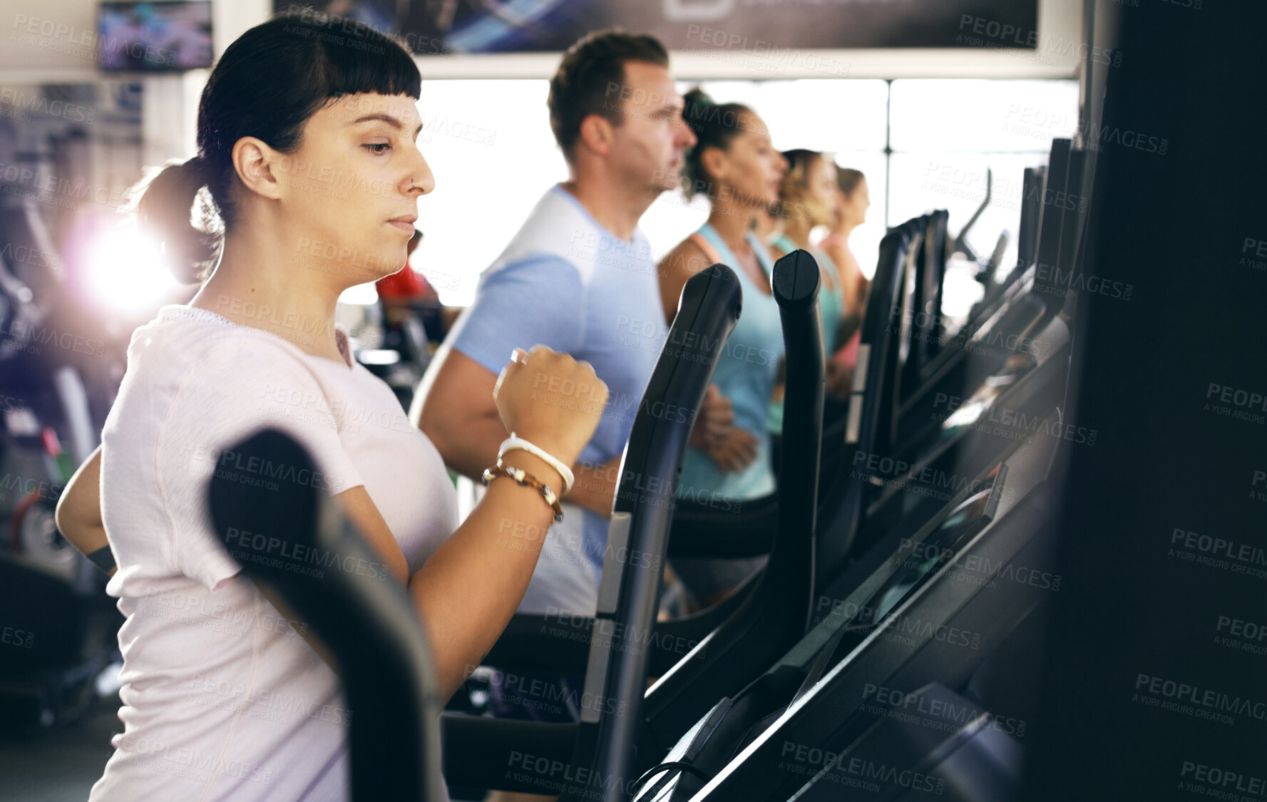 Buy stock photo Cropped shot of a group of young people working out on treadmills in the gym