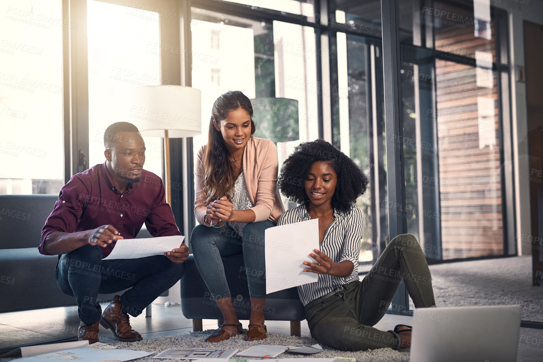 Buy stock photo Creative people, conversation and meeting with documents in office for sales plan, analysis and teamwork. Employees, discussion and paper with laptop on floor for kpi solution, strategy and feedback