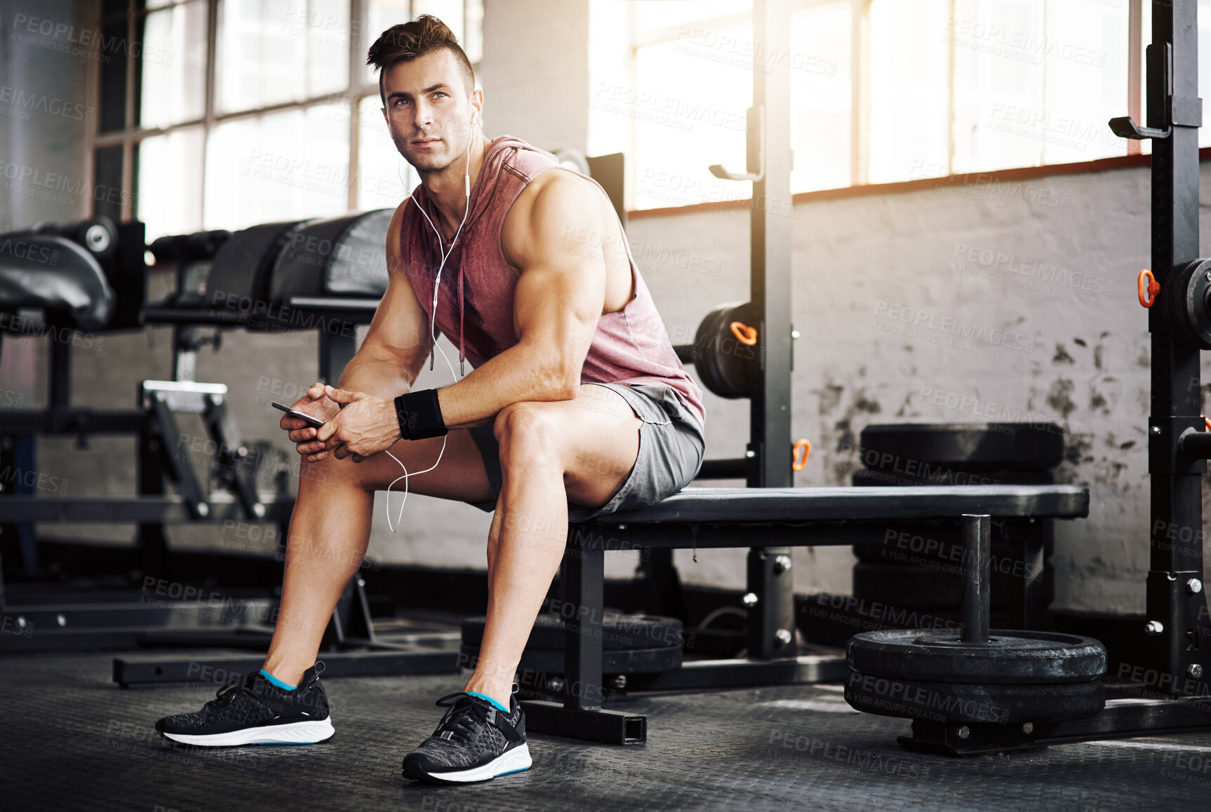 Buy stock photo Shot of a handsome young man taking a break during his workout at the gym